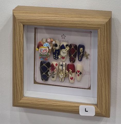 Jeu de press-on sur le thème des cartes à jouer, avec charm de clown et quadrillage doré, dans un cadre en bois.