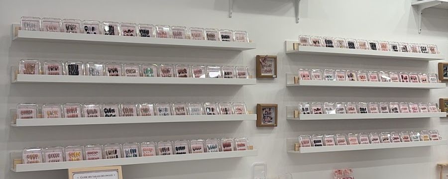 Étagères blanches alignées, chargées de boîtiers transparents.