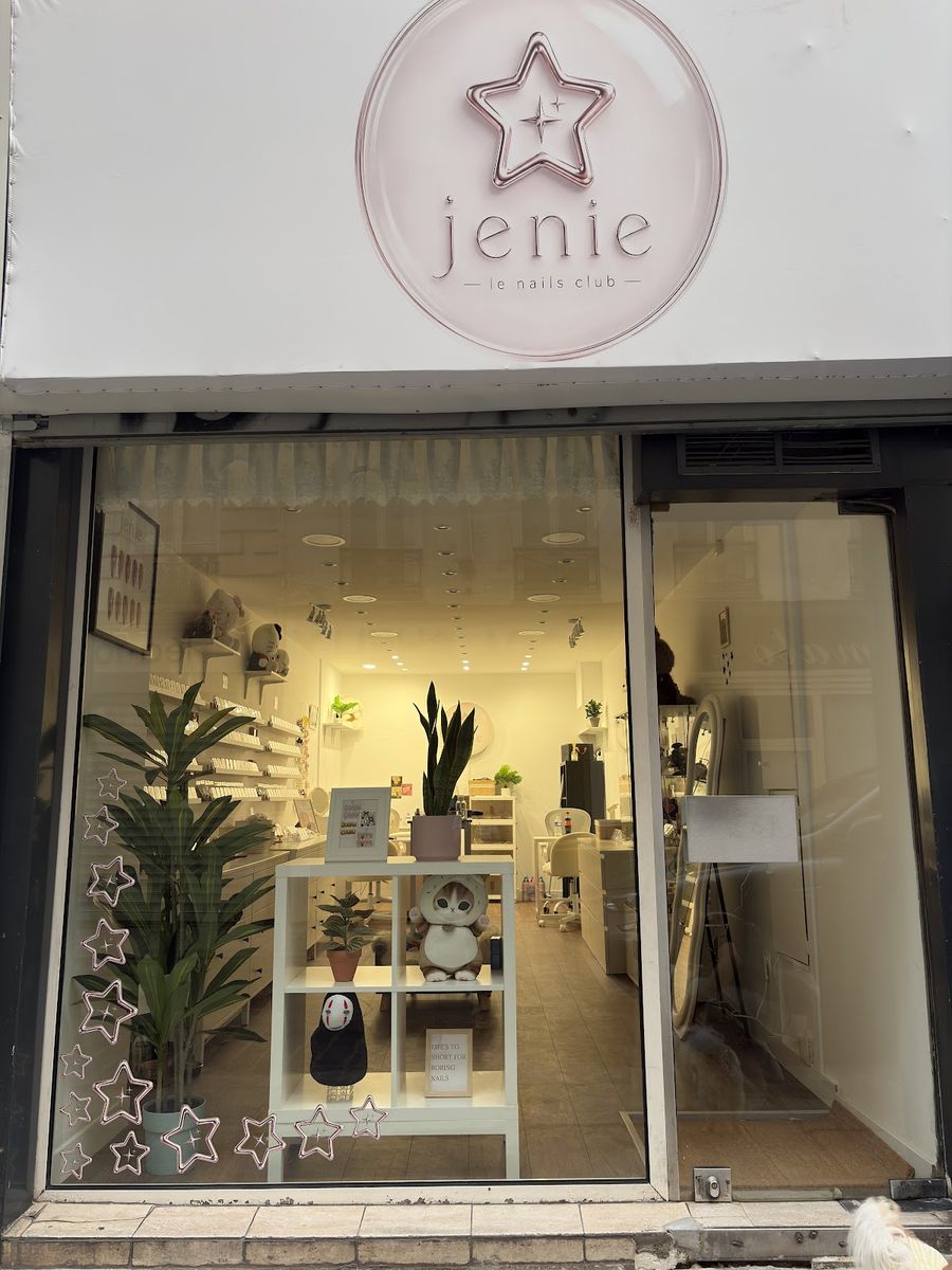 Façade de Jenie, le nails club : enseigne blanche à l’étoile rose, vitrine éclairée et étoiles collées sur la vitre.